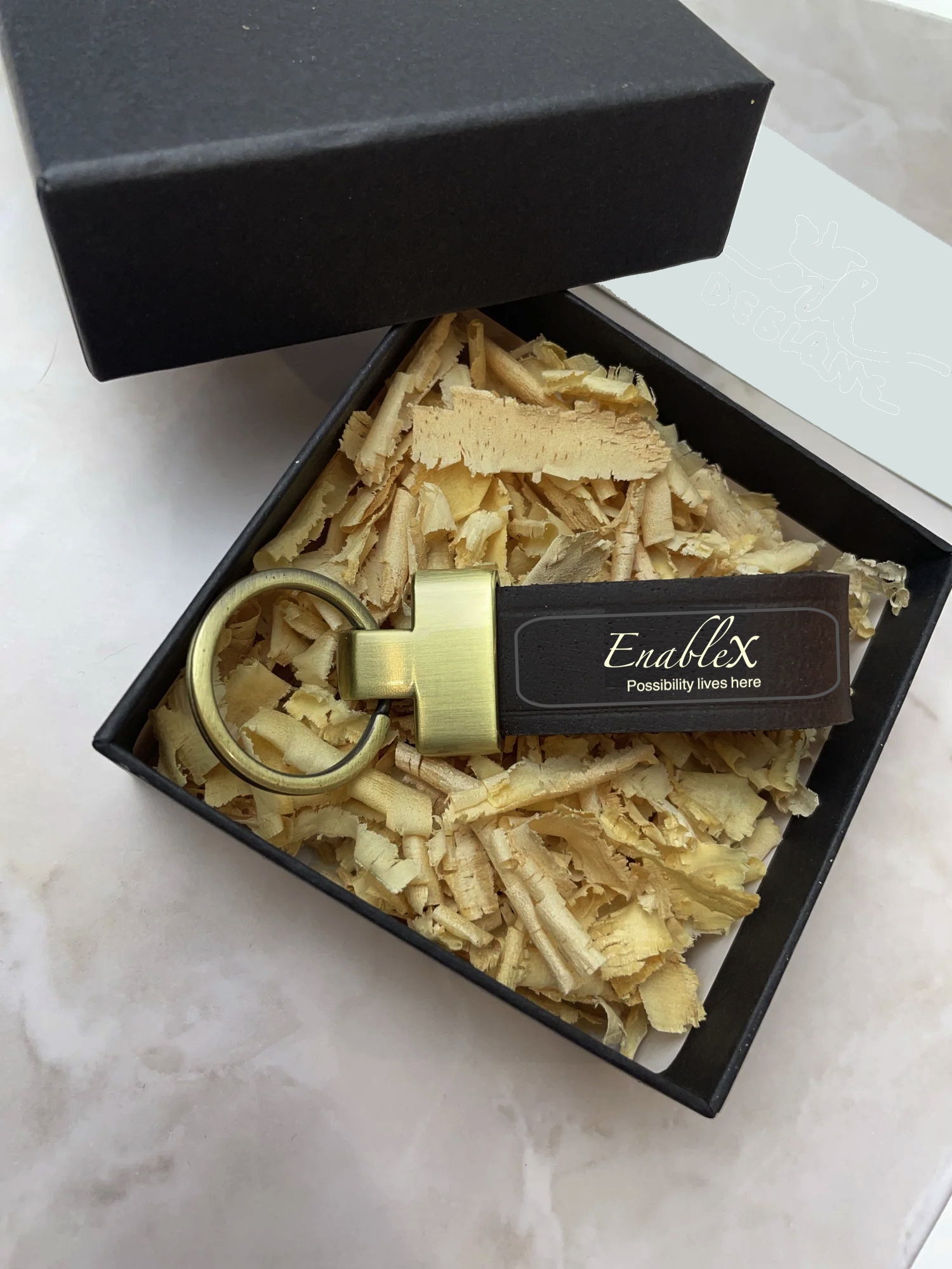 A wooden EnableX keychain and key resting on a timber tray, ready to open the door to a new home